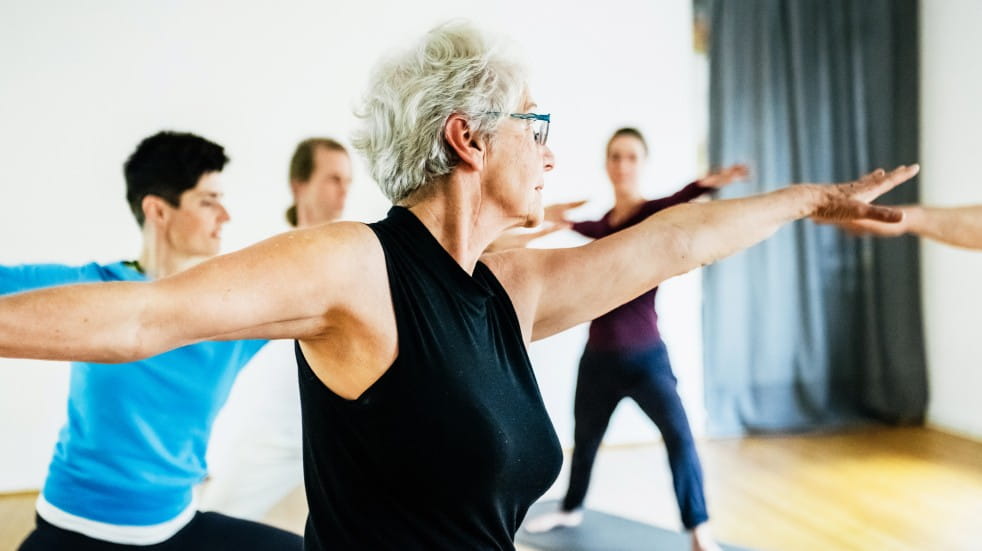 older people doing group yoga